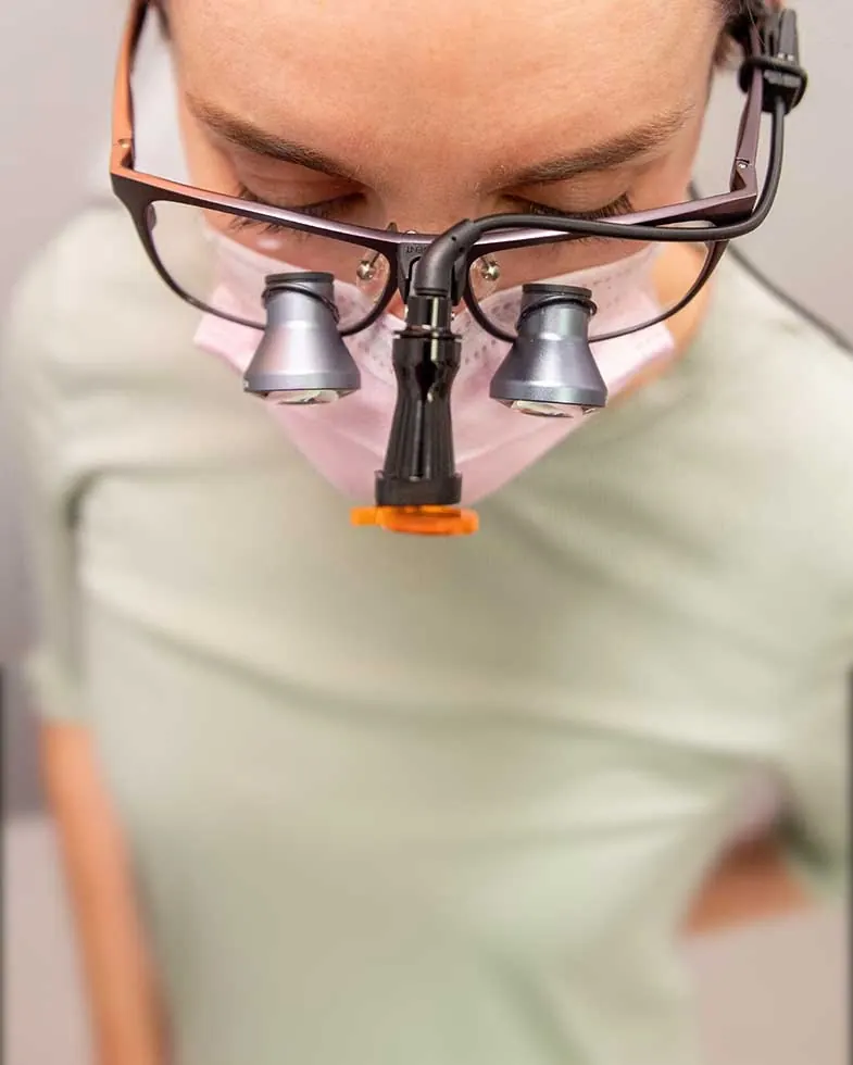 A clinician at 1330 Dental Associates wearing magnifying loupes.
